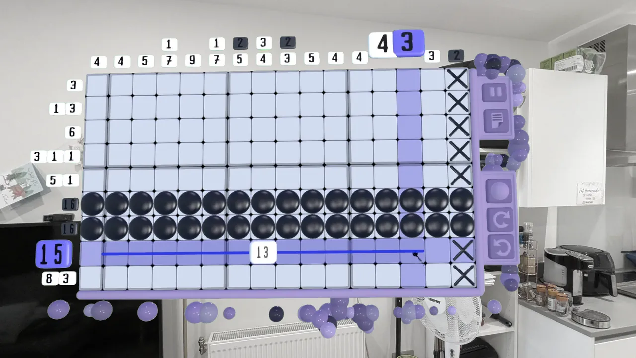 A wide nonogram mid-solve in a kitchen, with the drag ruler counting out a run of thirteen cells.